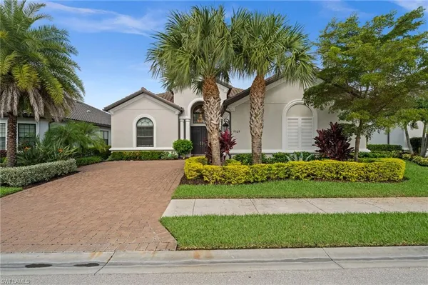 a front view of house with small garden and palm tree