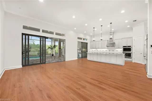 a view of an empty room with kitchen appliances and furniture