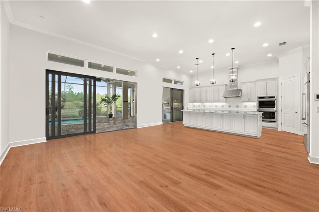 a view of an empty room with kitchen appliances and furniture