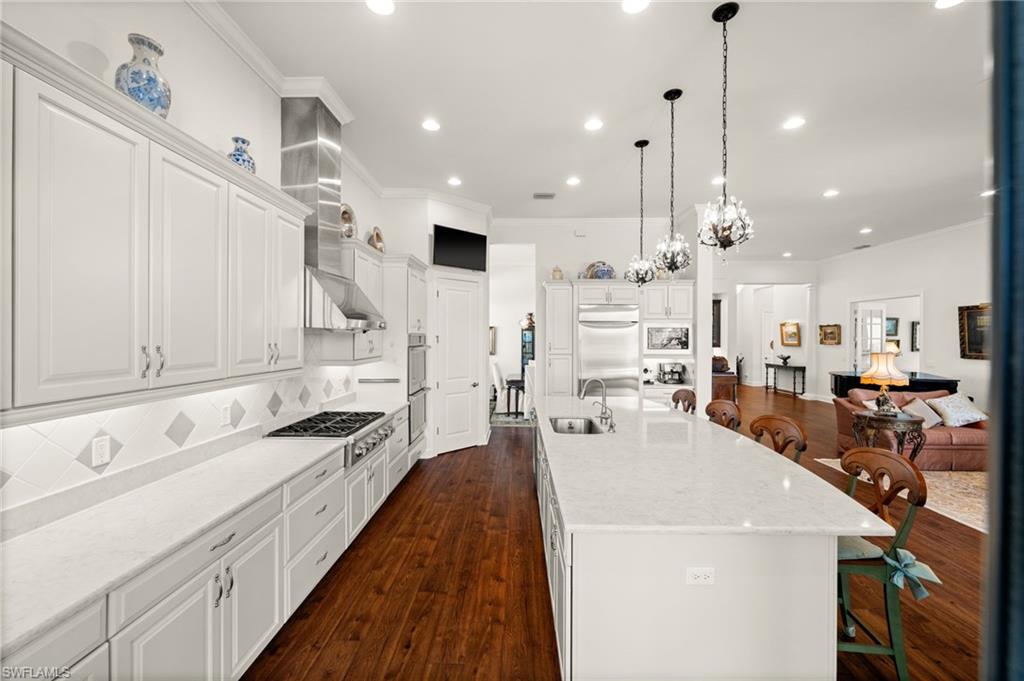 9509 Montelanico Loop Naples, FL 34119 - Photo 17 of 50 a large white kitchen with lots of counter space a sink appliances and cabinets