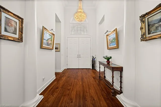 a view of a hallway with wooden floor and furniture