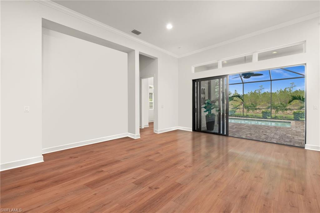 9509 Montelanico Loop Naples, FL 34119 - Photo 2 of 50 a view of an empty room with wooden floor and a window