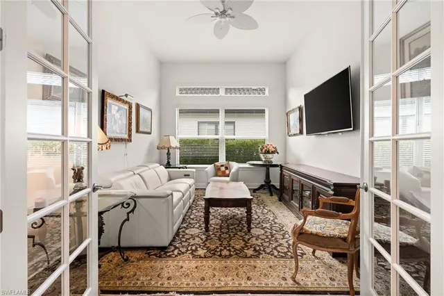 a living room with furniture a flat screen tv and a large window