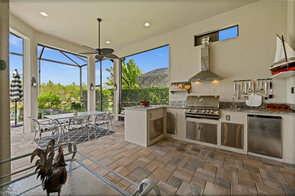 9509 Montelanico Loop Naples, FL 34119 - Photo 27 of 50 a kitchen with stainless steel appliances granite countertop a stove a sink and a refrigerator