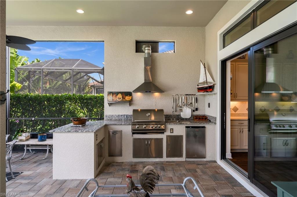 9509 Montelanico Loop Naples, FL 34119 - Photo 28 of 50 a kitchen with stainless steel appliances granite countertop a stove and a refrigerator