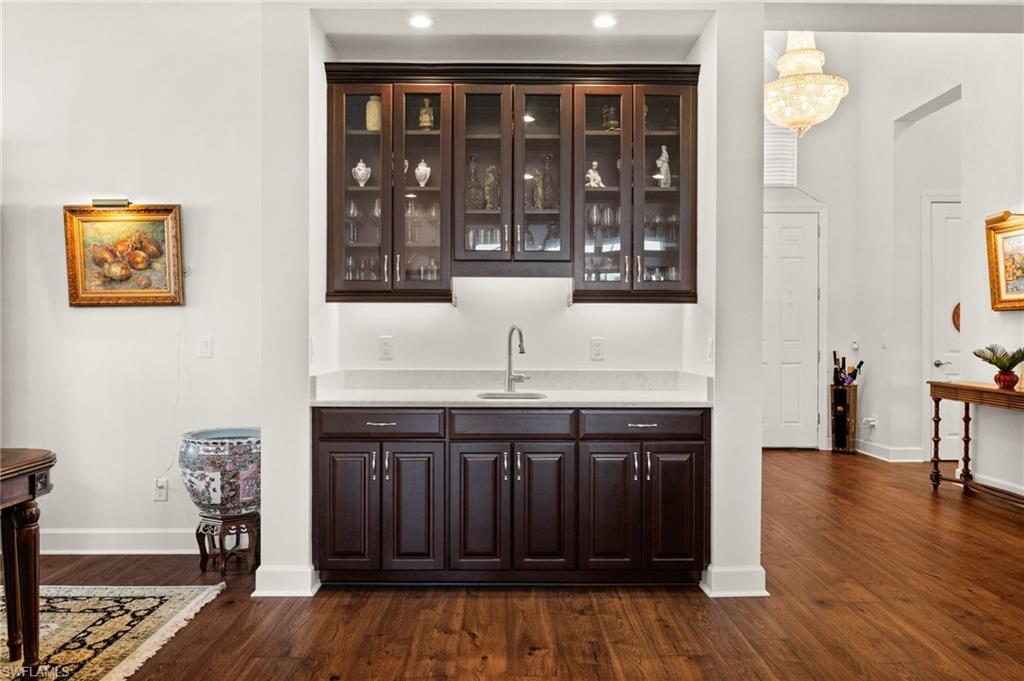 9509 Montelanico Loop Naples, FL 34119 - Photo 42 of 50 a kitchen with stainless steel appliances granite countertop a stove and a wooden cabinets