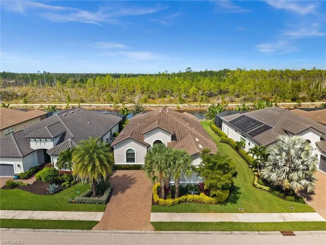 an aerial view of residential houses with outdoor space and trees