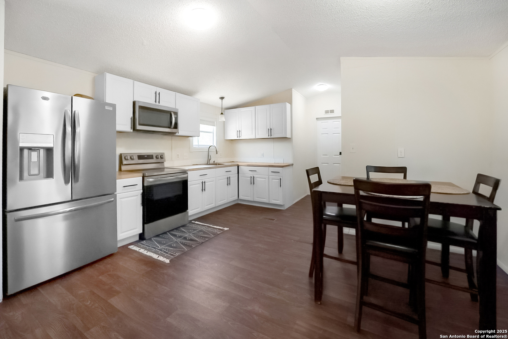 25335 Pleasanton Road San Antonio, TX 78264 - Photo 17 of 26 a kitchen with stainless steel appliances a table chairs microwave and sink