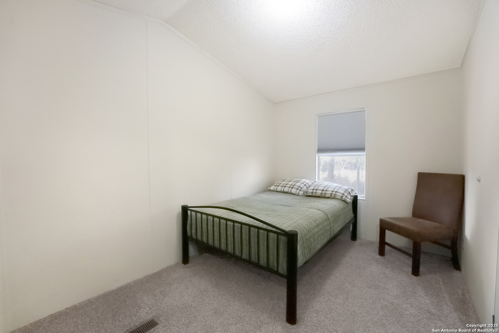 25335 Pleasanton Road San Antonio, TX 78264 - Photo 22 of 26 a bedroom with a bed and chair