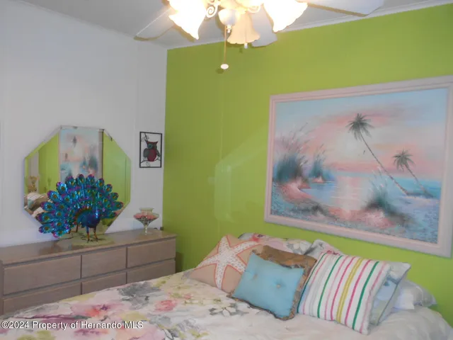 a bedroom with a bed plant and dresser