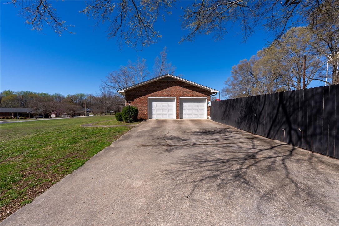 300 Green Street Williamston, SC 29697 - Photo 44 of 47 This property features a two-car garage with a spacious concrete driveway and a private yard.