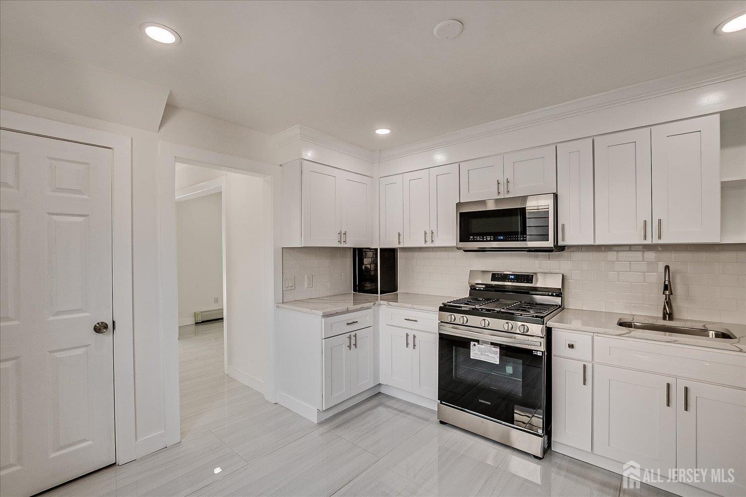 37 Summit Avenue Fords, NJ 08863 - Photo 15 of 28 a kitchen with white cabinets and white appliances