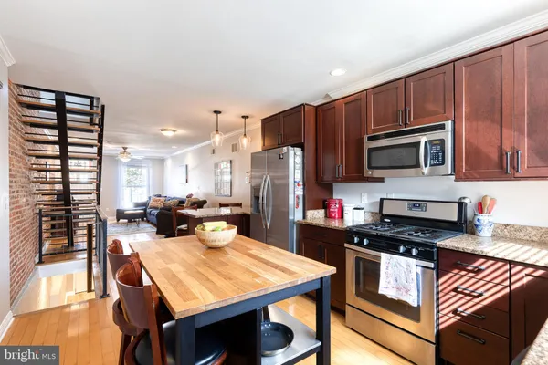 a kitchen with a stove a refrigerator and a dining table