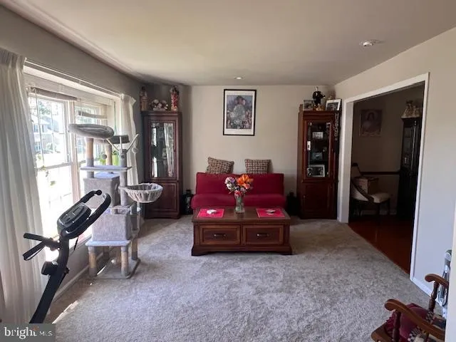 a living room with furniture a flat screen tv and a window