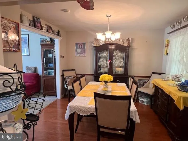 a view of a dining room with furniture a chandelier and wooden floor