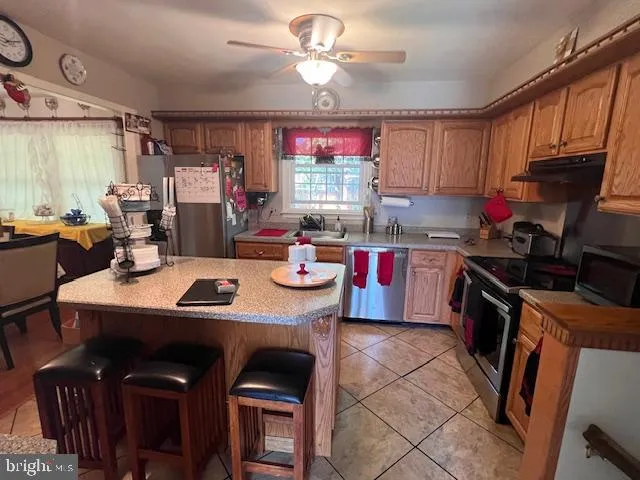a kitchen with kitchen island a stove a sink and a refrigerator