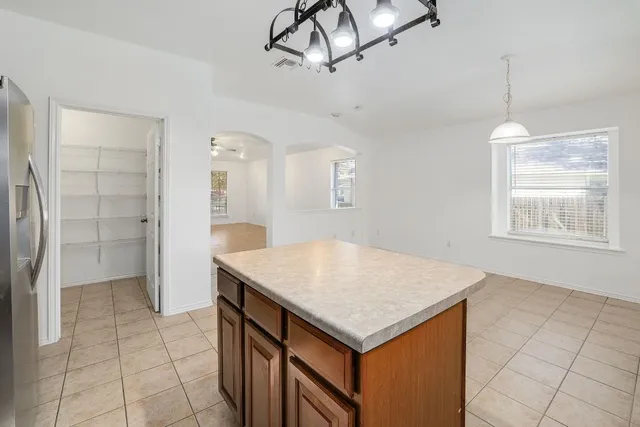 a open kitchen with a sink a refrigerator and chandelier