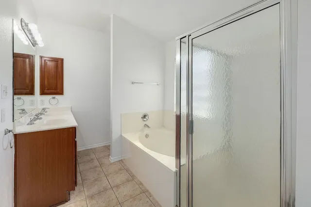 a bathroom with a bath tub sink shower and mirror