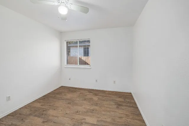 an empty room with a chandelier fan