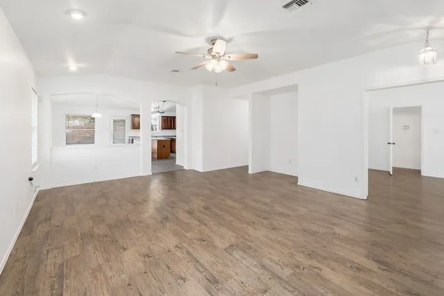 a view of a livingroom with a ceiling fan window and hardwood floor
