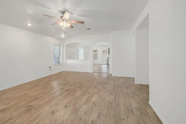 a view of an empty room with a chandelier fan