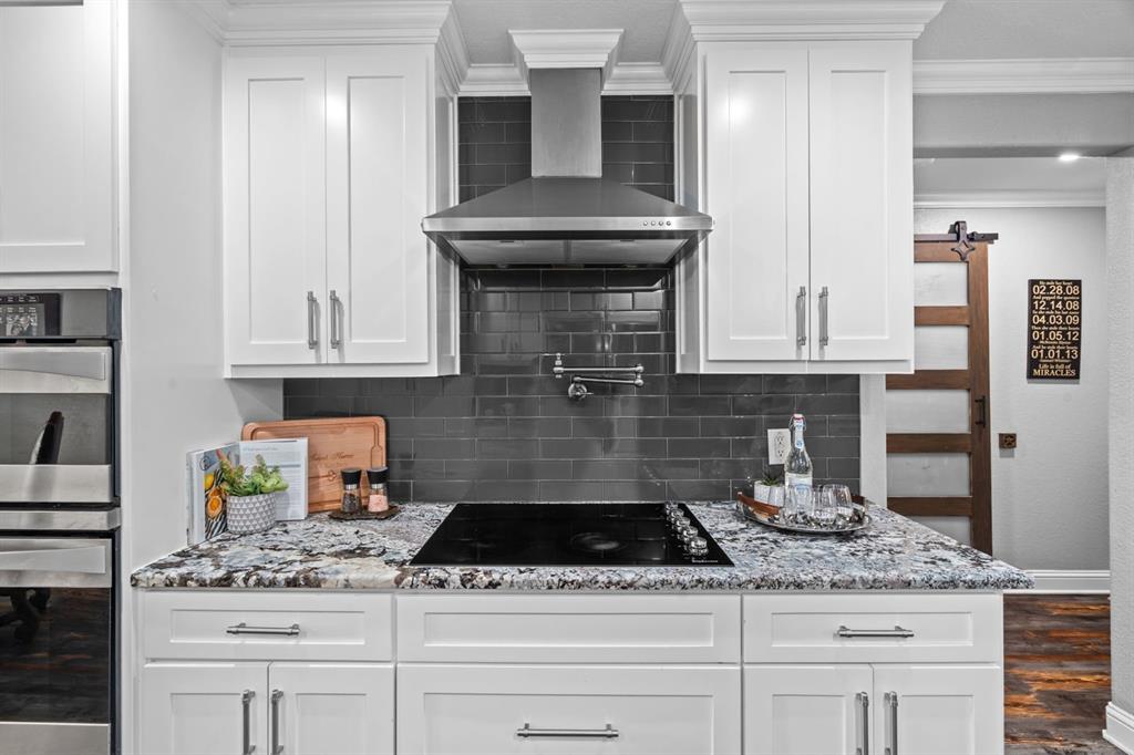 175 Porter Road Bartonville, TX 76226 - Photo 8 of 40 a kitchen with granite countertop a sink stainless steel appliances and white cabinets
