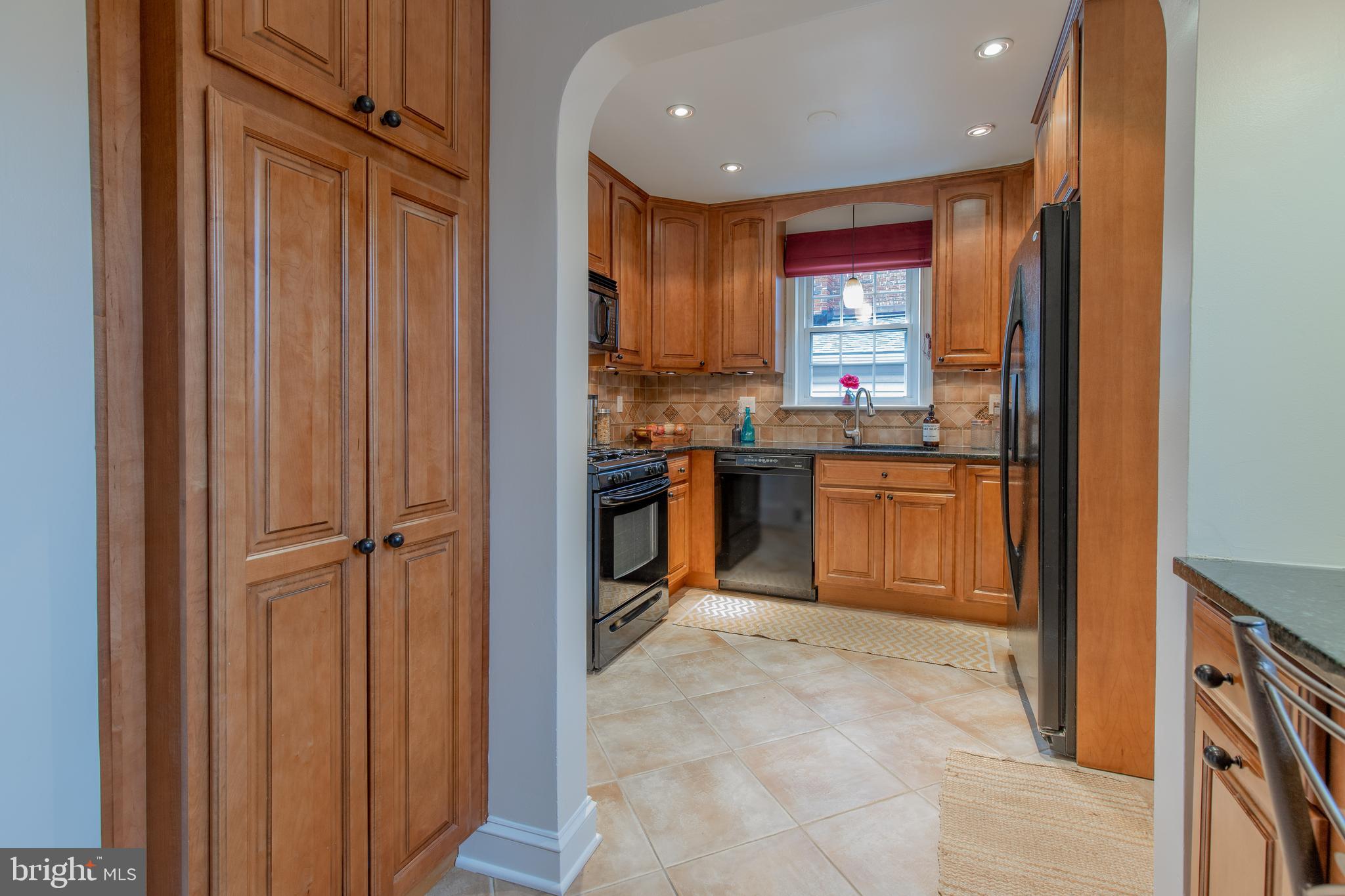 9416 Colesville Road Silver Spring, MD 20901 - Photo 14 of 40 a open kitchen with kitchen island a stove a refrigerator and cabinets