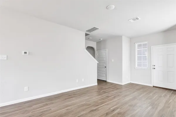 a view of a room with wooden floor and white walls