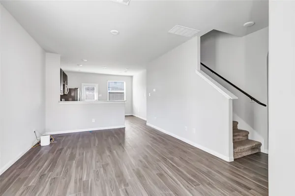 a view of a room with wooden floors and stairs