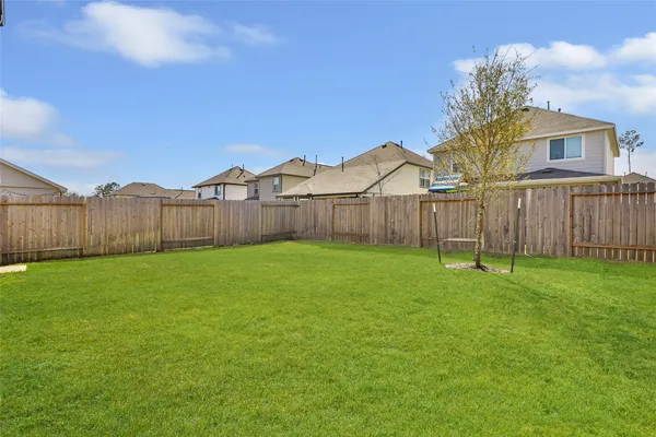 a view of a backyard with a garden and tree