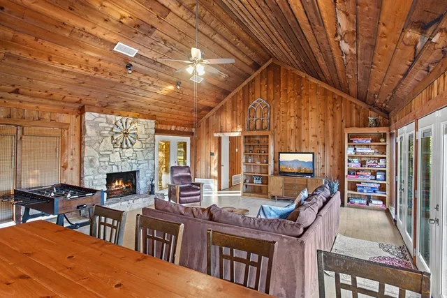 a living room with furniture a fireplace and large windows