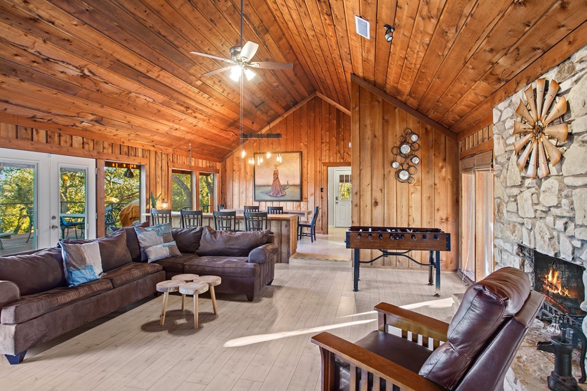 411 Whitetail Ridge Dripping Springs, TX 78620 - Photo 5 of 40 a living room with furniture a fireplace and large windows