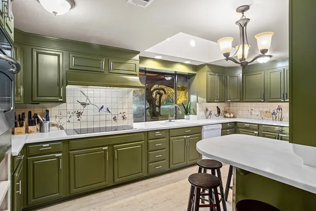 a kitchen with a table chairs refrigerator and cabinets