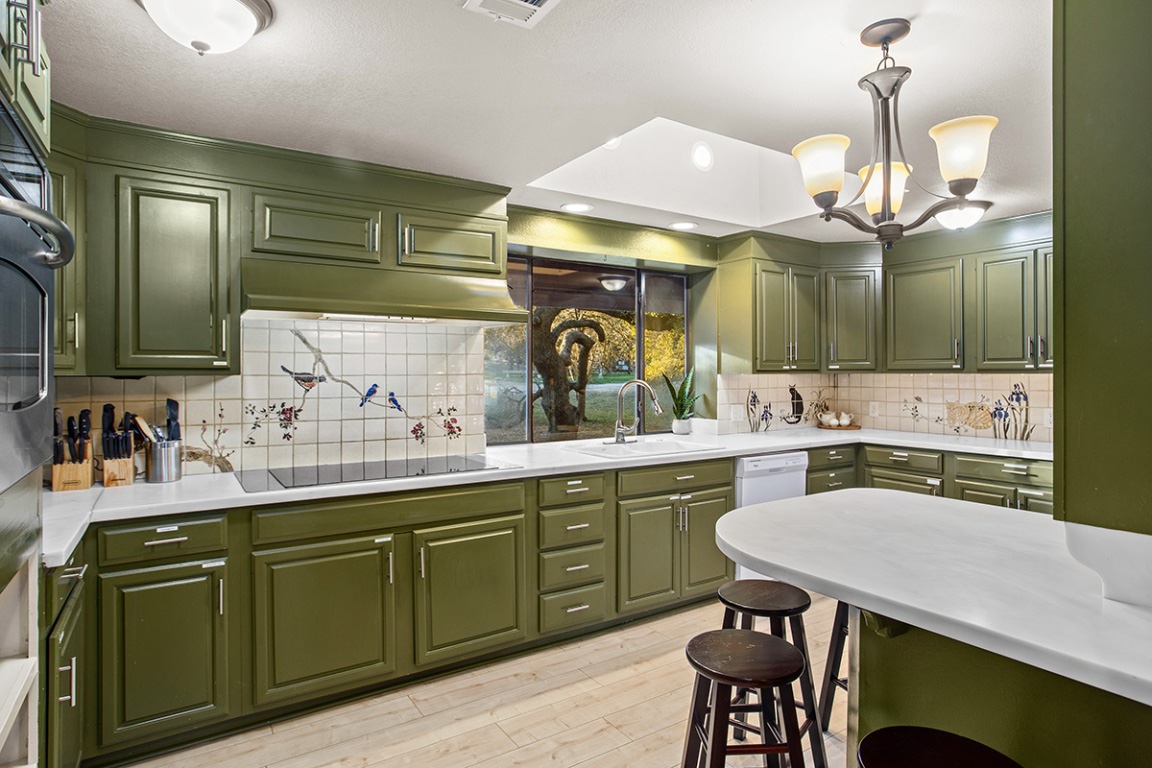 411 Whitetail Ridge Dripping Springs, TX 78620 - Photo 7 of 40 a kitchen with cabinets a sink and chairs