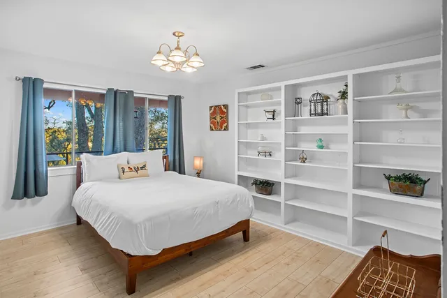 a bedroom with furniture and a large window