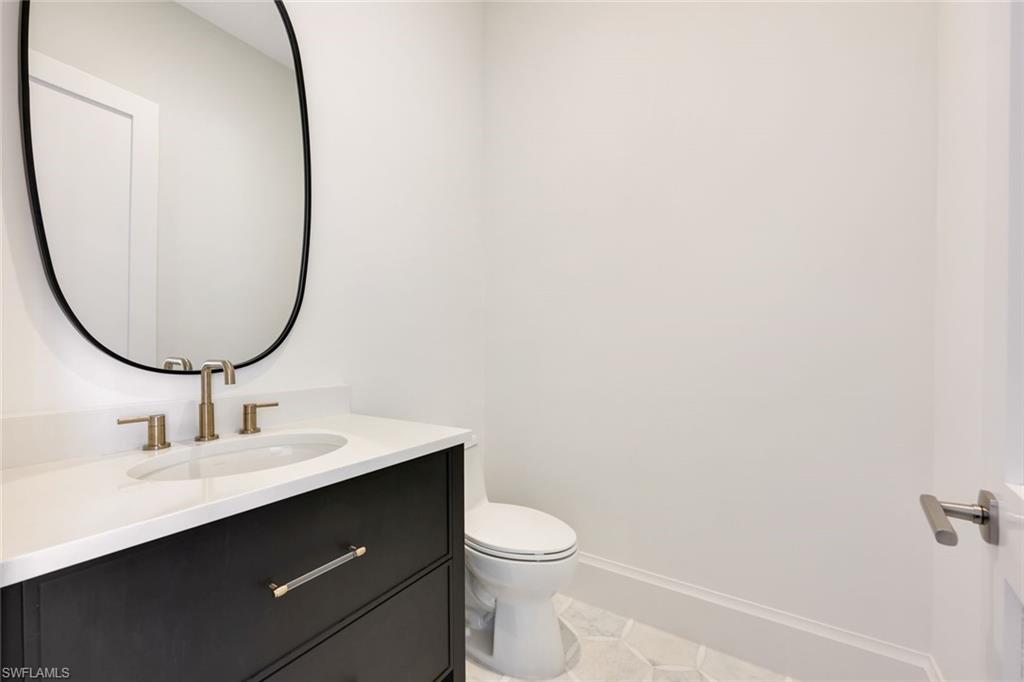 16728 Enclave Circle Naples, FL 34110 - Photo 16 of 50 a bathroom with a sink a mirror and a toilet