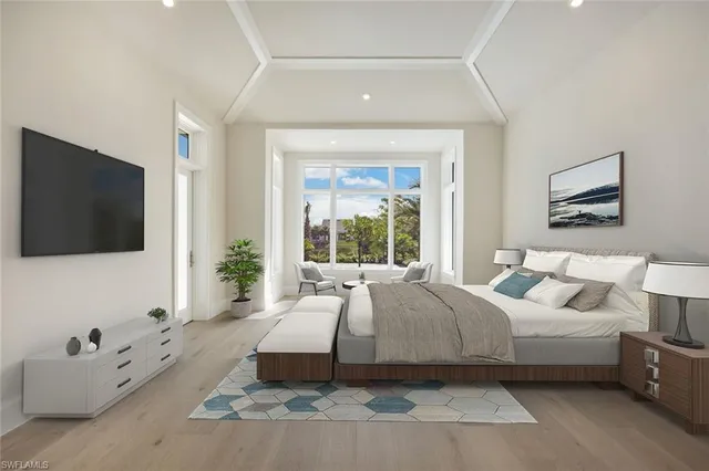 a spacious bedroom with a large bed and a flat screen tv