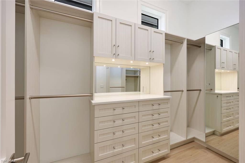 16728 Enclave Circle Naples, FL 34110 - Photo 22 of 50 a kitchen with white cabinets and refrigerator