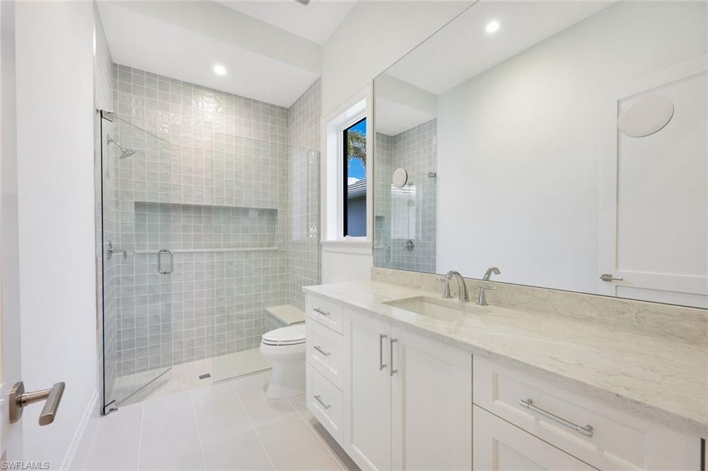 16728 Enclave Circle Naples, FL 34110 - Photo 24 of 50 a bathroom with a double vanity sink toilet and shower