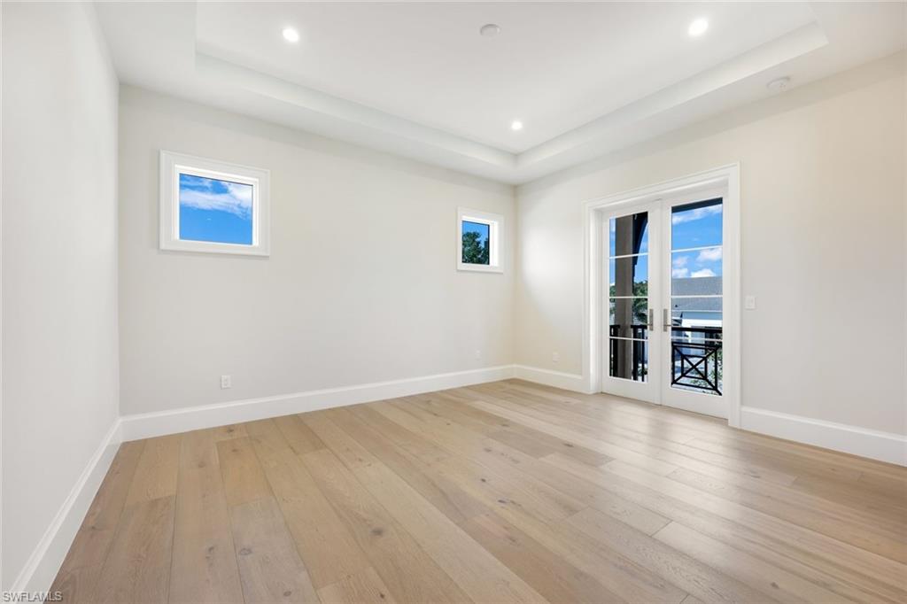 16728 Enclave Circle Naples, FL 34110 - Photo 25 of 50 a view of an empty room with wooden floor and a window