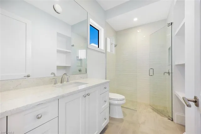 a bathroom with a granite countertop sink a toilet and a mirror