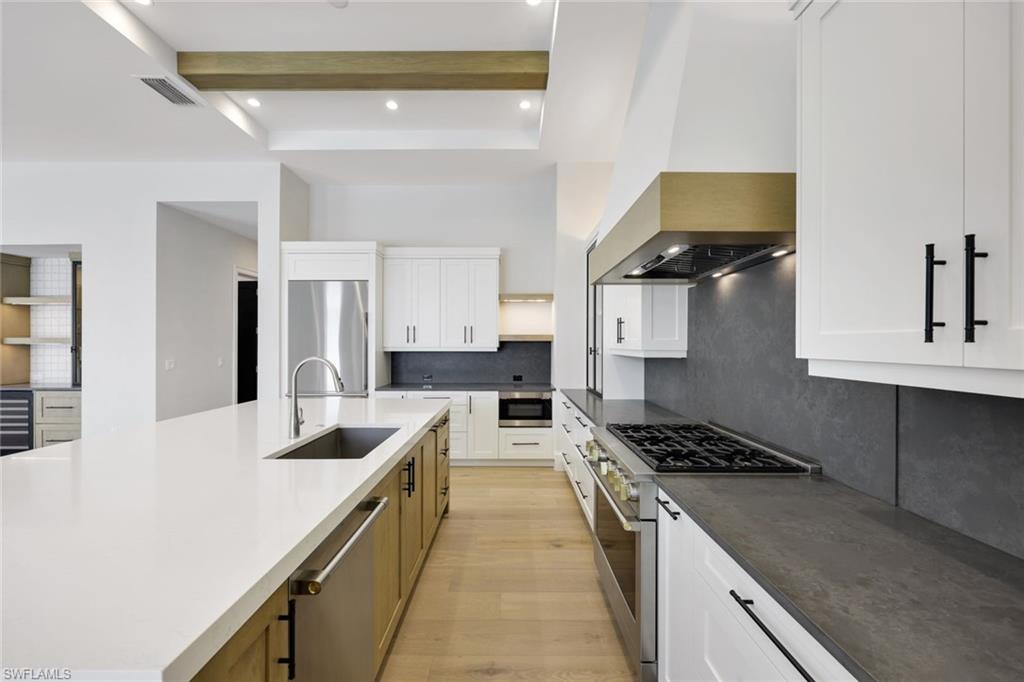 16728 Enclave Circle Naples, FL 34110 - Photo 6 of 50 a kitchen with stainless steel appliances kitchen island a sink stove and cabinets