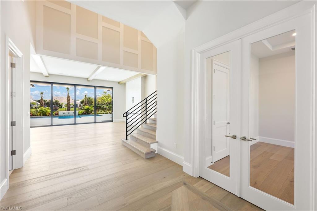 16728 Enclave Circle Naples, FL 34110 - Photo 7 of 50 an empty room with wooden floor and windows