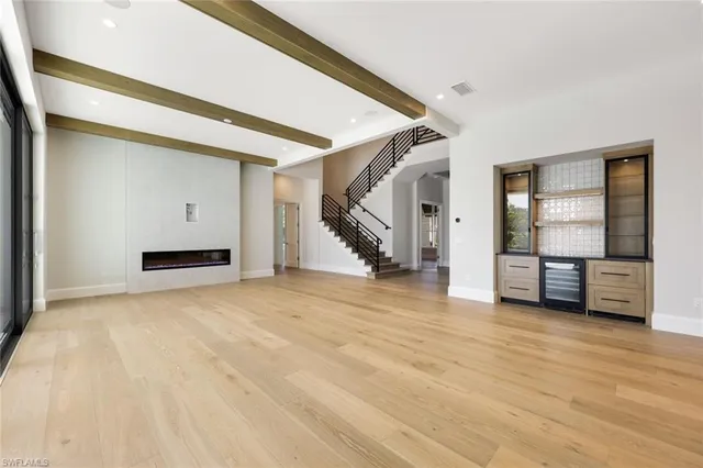 a view of an empty room with stairs and a window