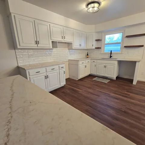 a kitchen with white cabinets and sink