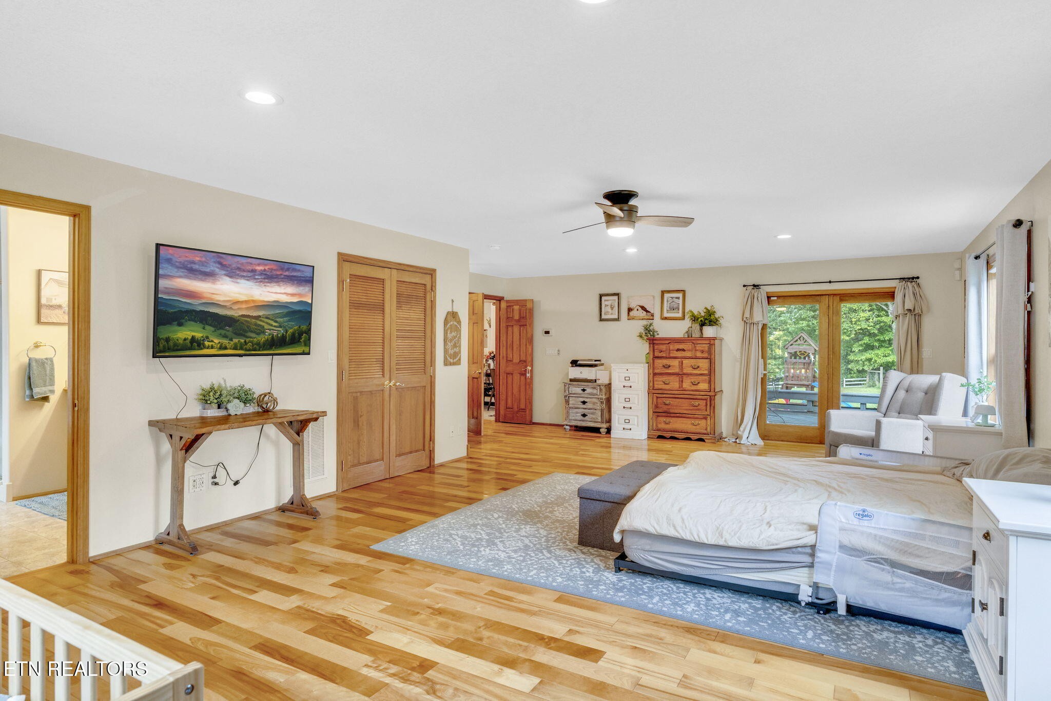 596 Clifty Creek Road Oakdale, TN 37829 - Photo 17 of 60 a bedroom with a large bed and a flat tv screen