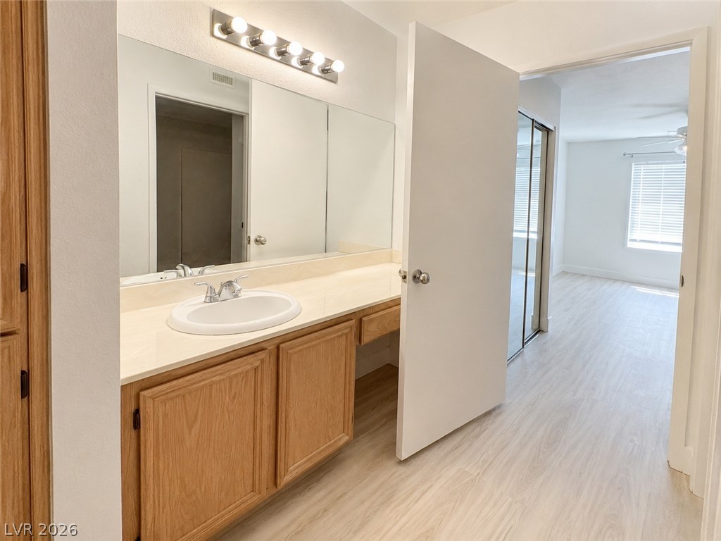 8070 West Russell Road, Unit 2023 Las Vegas, NV 89113 - Photo 4 of 6 A broad vanity with ample counter space and well-lit mirror, leading to an adjoining bedroom.
