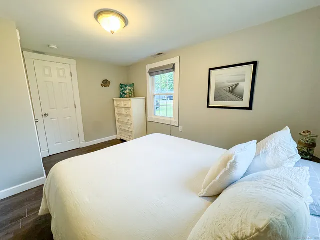 a bedroom with a bed and a painting on the wall