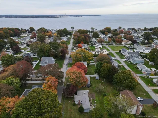 a view of a chairs and table in the patio next to a yard