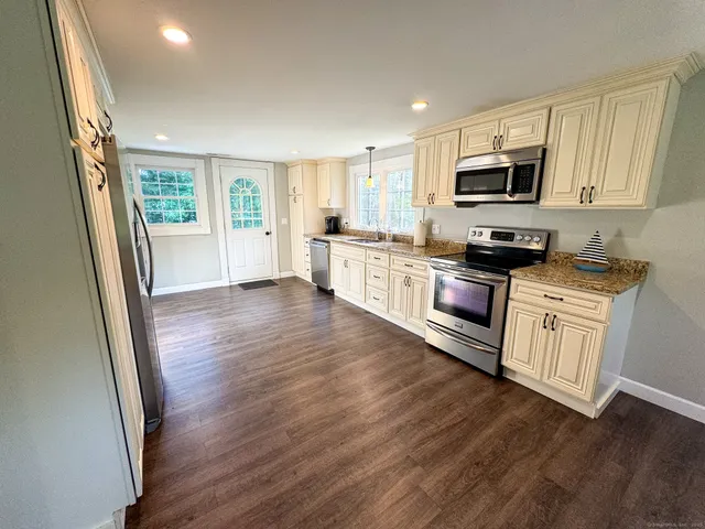 a kitchen with stainless steel appliances a white stove top oven a sink and a granite counter tops
